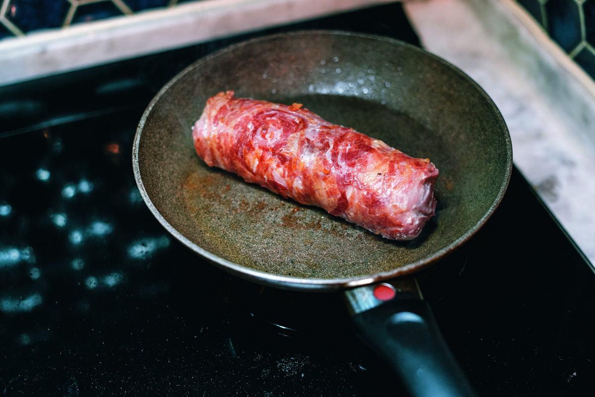 在里肌肉外一圈一圈裹上義大利培根，要完整包覆里肌肉，培根與培根的接口盡量排在同一面。（提供／有鹿文化）